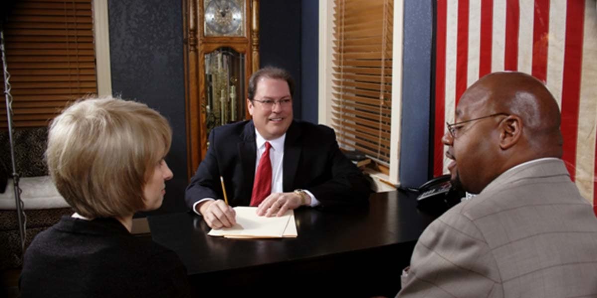 Robert McDorman meeting with clients about their auto insurance claim
